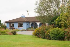 a blue house with a grassy yard at Gormans Country Home in Killarney +34 photos