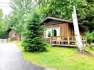 a wooden cabin in the woods with a path leading to it at High Falls Motel & Cabins in Wawa