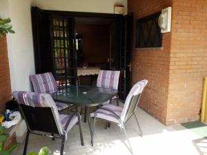 une table et des chaises assises sur une terrasse dans l'établissement GRAZIOSA casa vacanze tra sheraton hotel e baia verde hotel, à Aci Castello