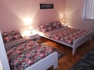 2 camas en una habitación pequeña con 2 lámparas en Apartments Dedic, en Dubrave Gornje
