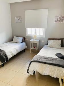 1 dormitorio con 2 camas y ventana en Villa Tías, en Tías