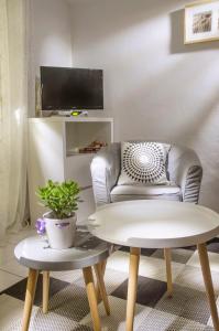 - un salon avec une chaise et une table dans l'établissement Apartments IDa II, à Baška