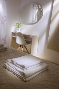 una pila de toallas sentadas en una cama con espejo en Apartments IDa II, en Baška
