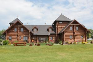 una cabaña de madera grande con un campo de césped delante de ella en Usedlost Gerstein, en Zálesí 10 fotos más
