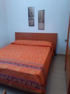 Bett in einem Zimmer mit zwei Bildern an der Wand in der Unterkunft In Primo Piano in Cava dʼAliga