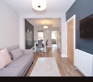 a living room with a couch and a dining room at Queens Quarter Townhouse 1 in Belfast