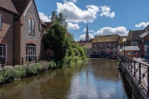 een rivier in een stad met gebouwen en een brug bij The Salisbury Townhouse in Salisbury