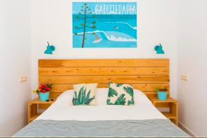 a bedroom with a bed with a wooden headboard at Nexo Surf House in El Palmar