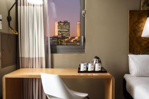 a hotel room with a desk and a bed and a window at ibis London City - Shoreditch in London