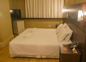 une chambre d'hôtel avec un lit et des serviettes. dans l'établissement San Juan Business São Paulo, à São Paulo