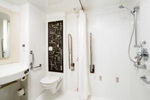 a bathroom with a toilet and a sink and a shower at ibis London City - Shoreditch in London