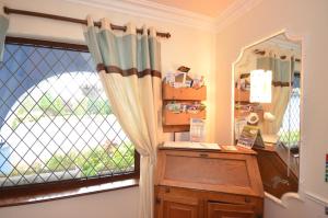 a room with a window with a dresser and a mirror at Gormans Country Home in Killarney