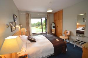 um quarto de hotel com uma cama grande e uma janela em Gormans Country Home em Killarney