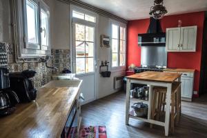 a kitchen with red walls and a wooden counter top at LE JABLOIRE in Florent-en-Argonne +43 photos