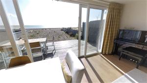 a living room with a balcony with a piano at Pevensey Beach Retreat in Pevensey