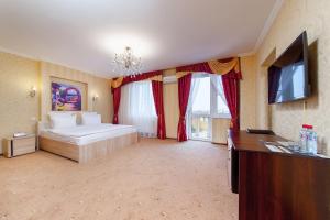 a bedroom with a bed and a flat screen tv at Hotel Vision in Krasnodar