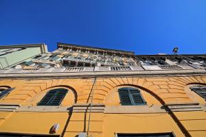 a tall building with a clock on it's side at La Superba Rooms & Breakfast in Genoa