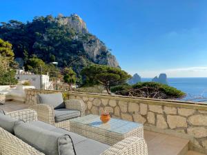 een patio met stoelen en een tafel en de oceaan bij Casa Fiore in Capri
