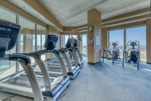 a gym with rows of cardio machines and windows at Lighthouse in Gulf Shores