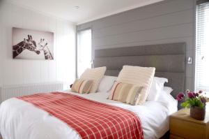 a bedroom with a bed with a red and white blanket at Hollicarrs - Honeycomb Lodge in York