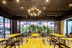 a restaurant with tables and chairs and a chandelier at Aliz Hotel in Nonthaburi