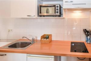 La cuisine est équipée d'un évier et d'un four micro-ondes. dans l'établissement Appartement des amoureux, à Uzès