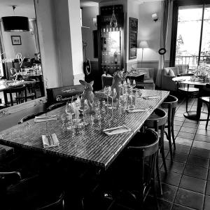 a table with wine glasses on it in a restaurant at Les Terrasses de David et Louisa in LʼIsle-sur-la-Sorgue