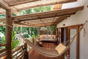 a hammock on the porch of a house at Etnia Casa Hotel in Trancoso
