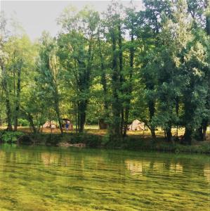 una tenda e una vista su un fiume alberato. di Robinson camp Kupa - Juratovićki brig a Netretić
