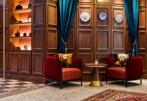 due sedie e un tavolo in una stanza con pareti in legno di Hotel Indigo Venice - Sant'Elena, an IHG Hotel a Venezia