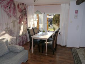 a dining room with a table and chairs and a couch at Elfenhäuschen mit 3 DTV Sternen ausgezeichnet in Bad Harzburg