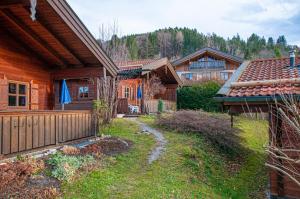 uma cabana de madeira com um caminho que conduz a uma casa em Ruhige Chalets mit Seeblick in zentraler Lage em Schliersee