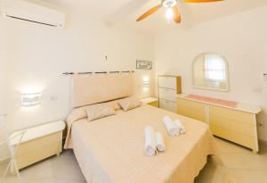 um quarto com uma cama com sapatos brancos em Sardinia-Holiday La casa delle Pavoncelle em La Maddalena