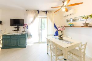 a dining room with a table and a ceiling fan at Sardinia-Holiday La casa delle Pavoncelle in La Maddalena