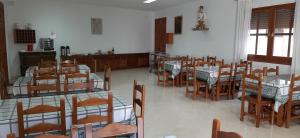 una sala da pranzo con tavoli e sedie in una stanza di Convento Madre de Dios de Carmona a Carmona