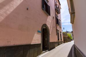 Une allée avec une arche dans un bâtiment rose dans l'établissement La Marinella, à Sorrente