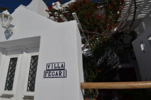 um sinal na lateral de um edifício branco em Villa Fegari em Firostefani