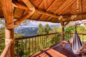 a porch with a hammock and a view of the mountains at Hotel Kawa Mountain Retreat in Salento