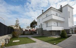 une maison blanche avec un mur en pierre dans l'établissement Guesthouse Porto di Roma, à Civitavecchia