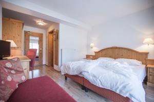 1 dormitorio con 1 cama blanca grande y escritorio en Hotel Innerhofer, en Gais