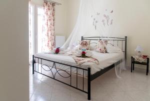 1 dormitorio con 1 cama con sábanas y almohadas blancas en Port View House, en Parasporos
