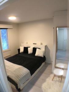 Un dormitorio con una cama en blanco y negro y un espejo en FREE downhill skiing ticket 1pcs Cozy and very peaceful place in Levi, en Kittilä