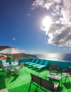 um pátio com cadeiras e uma mesa e o oceano em Surf House la Palma em Fuencaliente de la Palma