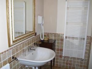 ein Bad mit einem Waschbecken und einem Spiegel in der Unterkunft Locanda Martelletti in Cocconato