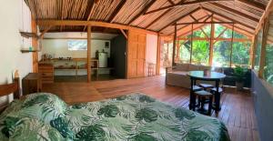 a bedroom with a bed and a table in a room at Private jungle “Loft del Rio” river access in Uvita