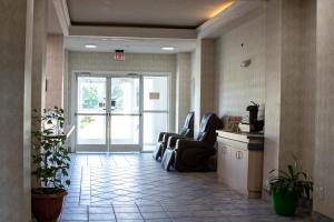 un vestíbulo de oficina con sillas y una puerta de salida en Morgantown Inn & Suites, en Morgantown