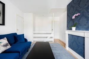 salon z niebieską kanapą i kominkiem w obiekcie The Bluebird - One Bedroom Apartment in Watford w mieście Watford