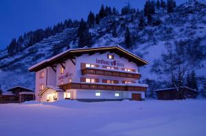 Ein Gebäude mit einem Schild im Schnee. in der Unterkunft Landhaus Maria in Stuben am Arlberg
