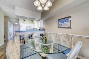 une salle à manger avec une table et des chaises en verre dans l'établissement Sundance East, à Gulf Shores