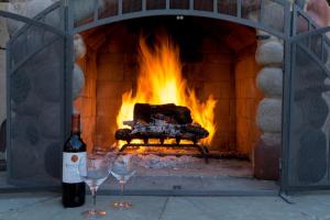 a fireplace with two wine glasses in front of it at The River Road Retreat at Lake Austin-A Luxury Guesthouse Cabin & Suite in Austin